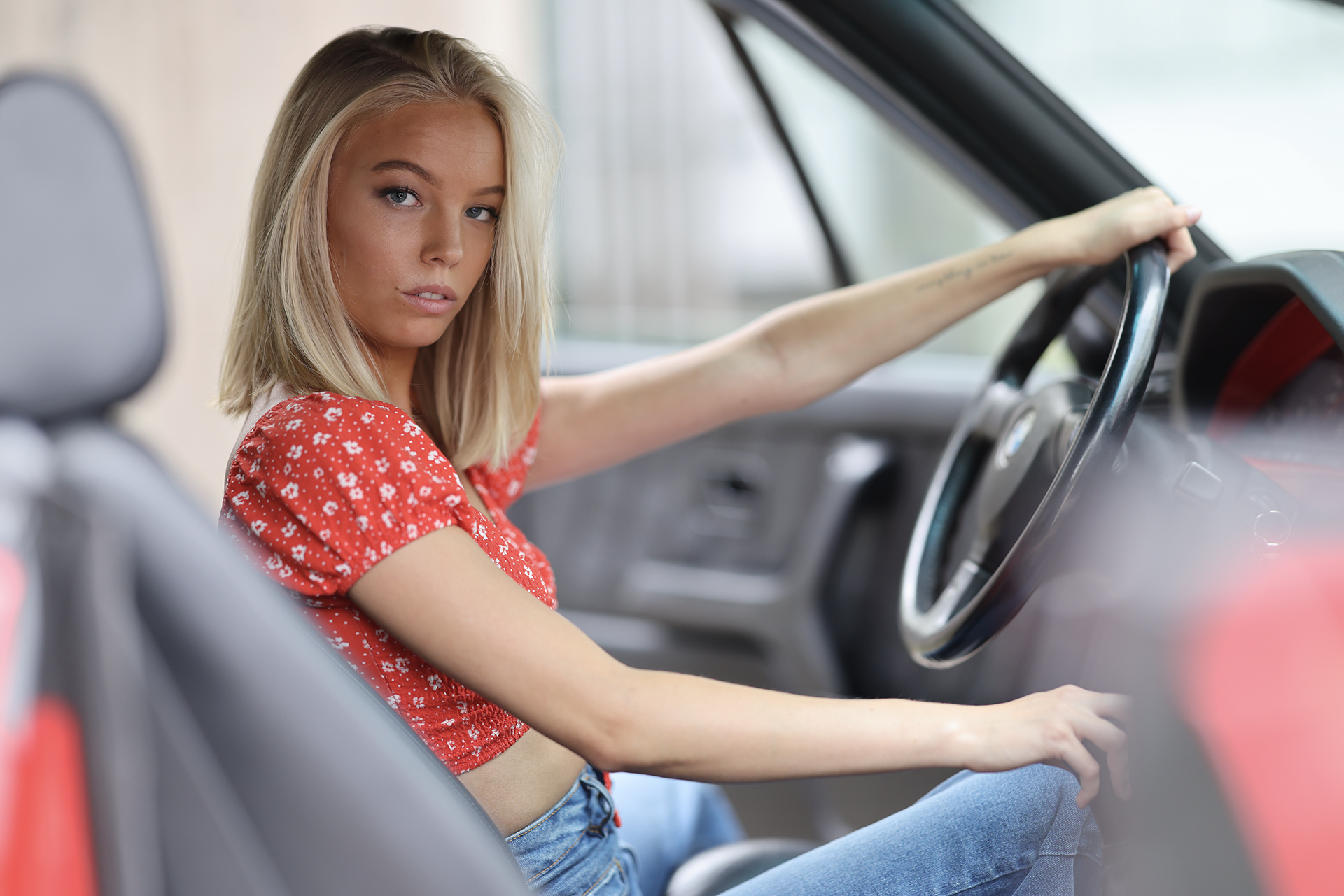 Portrait of blonde model in a classic car, taken with the Canon EOS R5 II and RF 85mm F1.2L lens