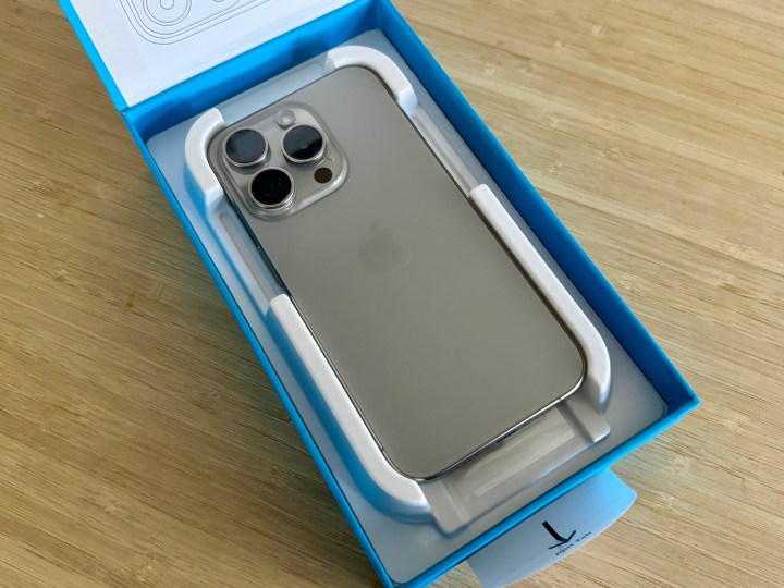 An iPhone 15 Pro face down in the Anker iPhone 15 Pro screen protector box tray.