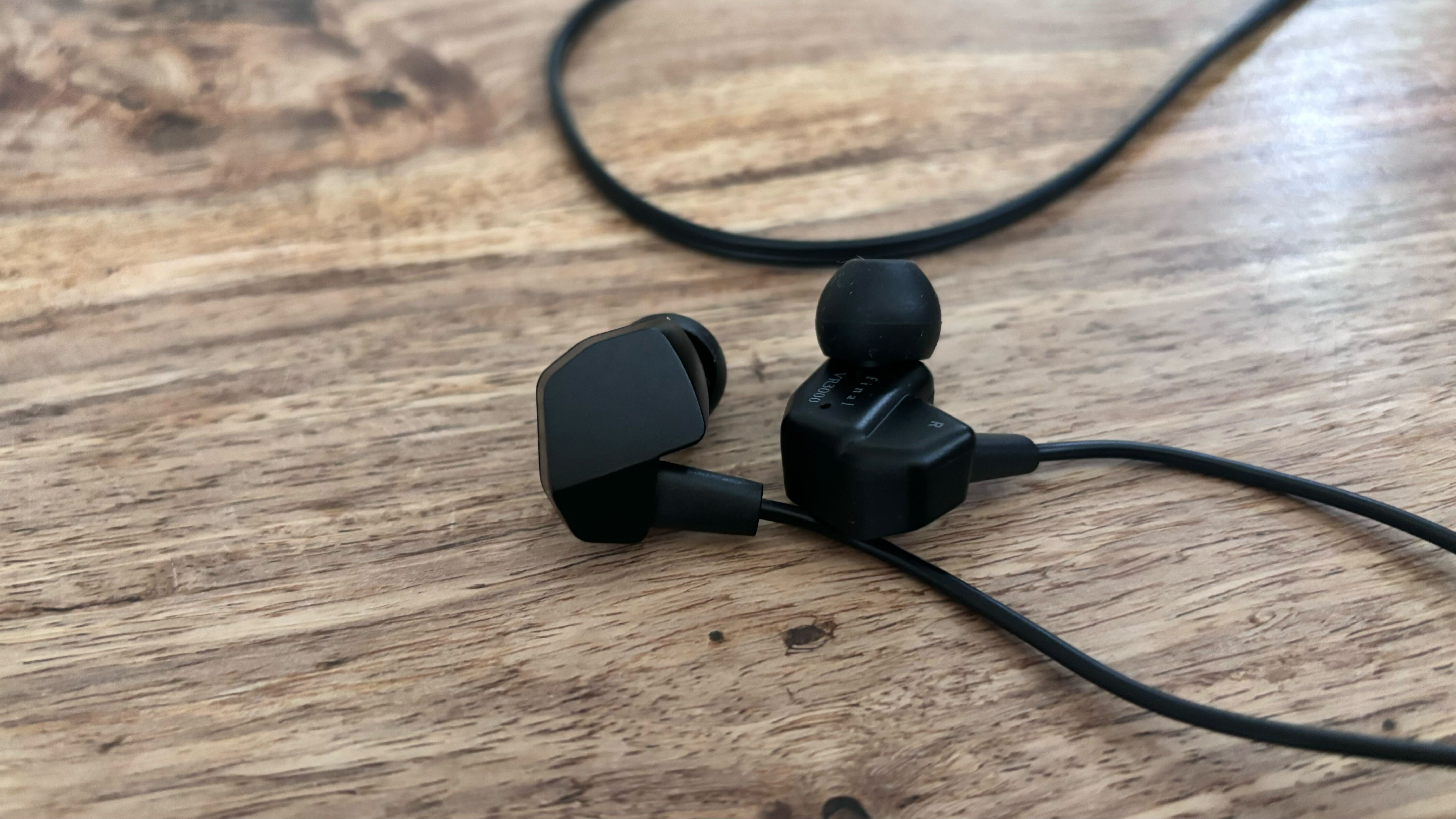 A shot of the Final VR3000 earbuds on a wooden table.