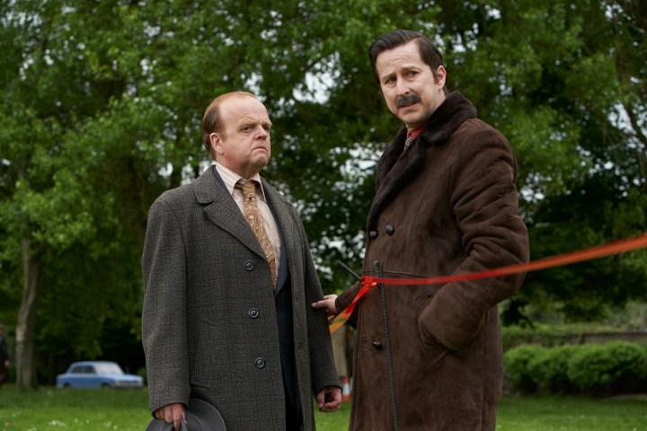 Two men stand at a crime scene in The Long Shadow.